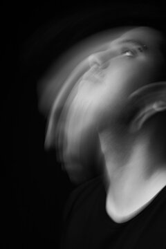 Black and white moving and conceptual portrait of a latin american man with dark background