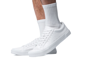 Closeup of male feet and shoes. Man wearing white trainers on white background.