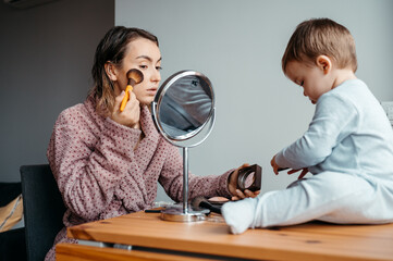Mom making up and baby playing beside