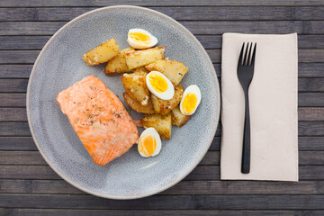 baked salmon fillet with fried potato wedges and quail eggs halves