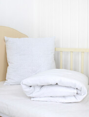 White blanket and pillow on the crib. A template for a mockup overlay patterns. Newborn bed