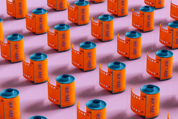 Orange film rolls on pink background
