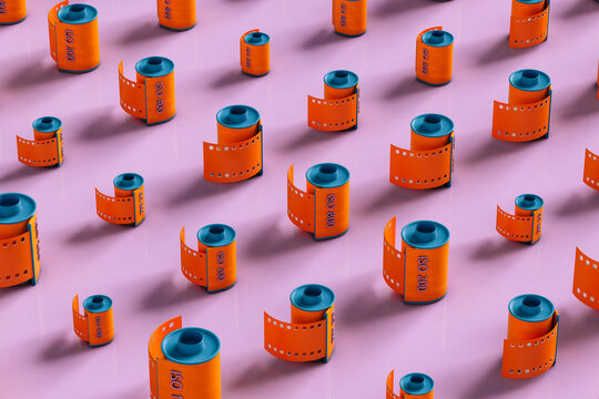 Orange film rolls on pink background - different sizes
