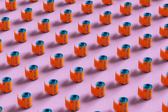 Orange film rolls on pink background