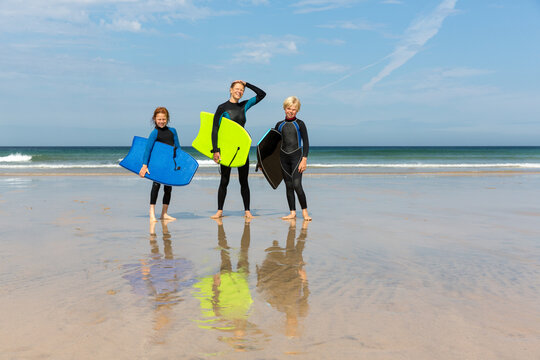 Family in wetsuits on beach