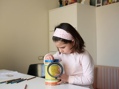 Little girl choosing colour of pencil.