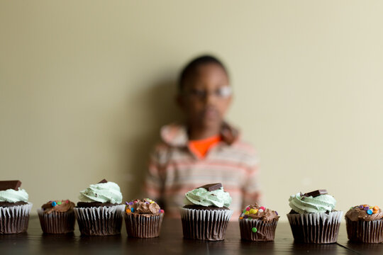 Row of decorated cupcakes on table