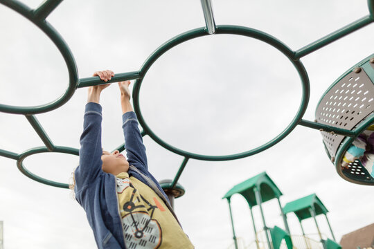 boy hanging from playground equipment