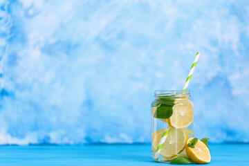 Tasty cool beverage with lemon and basil in mason jar glass