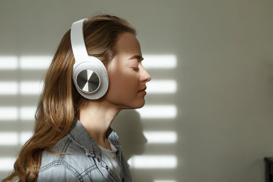 Woman listening to music in headphones at home