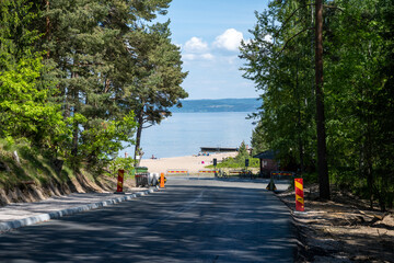 A newly paved road down to Lake Vattern a hot summer day. Picture taken from the shade of pine trees at Domsand beach, Habo