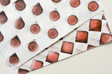abstract background composition with reddish-black (brown) ink pad stamped loosely arranged on light background - photographed from above in a flat lay style