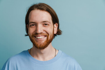 Young ginger man with beard smiling and looking at camera