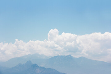 white fluffy clouds, blue sky and mountains