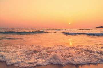 Fototapeta premium Tropical beach with smooth wave and sunset sky abstract background.