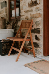Fototapeta na wymiar Wooden Chair against stone wall 