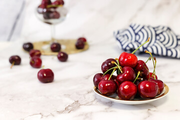 bowl of cherries on marble background and wicker tablecloth