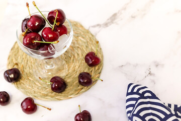 bowl of cherries on marble background and wicker tablecloth
