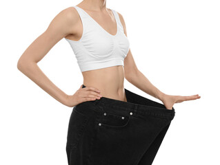 Young woman wearing big jeans after weight loss on white background, closeup