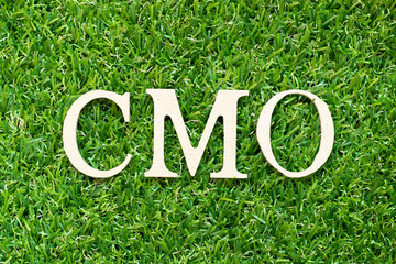 Alphabet letter in word CMO (Abbreviation of Chief Marketing Officer, Contract Manufacturing Organization) on green grass background