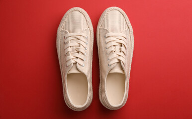 Pair of stylish comfortable shoes on red background, flat lay