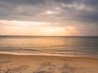 adstract color of yellow beach in golden sunset at the beach. dramatic gray cloudy sky above sea water