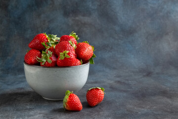 Strawberries and blueberries in a cup, on a wooden table. Blurred background. Rustic style. Healthy diet. High quality photo