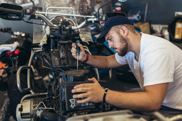 Fototapeta na wymiar Professional motorcycle mechanic working in bike repair service