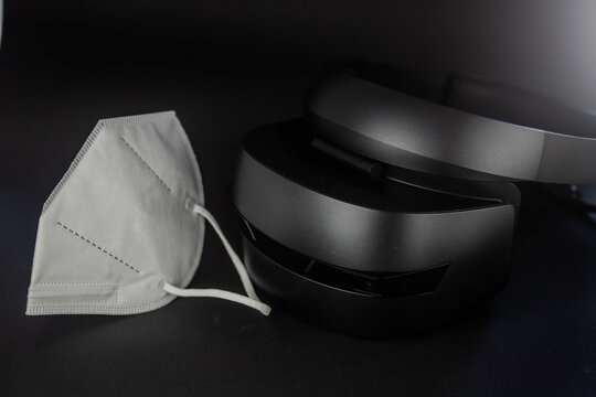 Virtual reality glasses in the covid-19 times. Virtual reality in times of pandemic. Virtual reality equipment and covid mask.