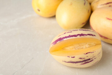 Cut and whole pepino melons on light table, space for text