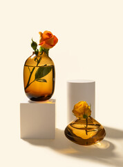 Roses in glass vases and white cylinder and cube podiums on beige background with hard long shadows front view, vertical. Creative composition