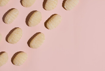 Gnocchi not ready on a pink background. View from above. Copy space. Italian food