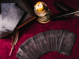 Divination cards, candles and dark background. View from above. Close-up
