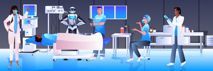 surgeons with robotic assistant making operation to patient lying on bed emergency medical treatment