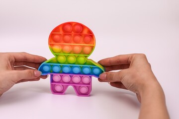 hands holding a colored toy antistress pop it. on a white background, close-up.