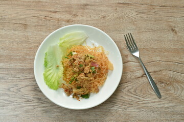 glass noodles with pork spicy salad and lettuce on plate