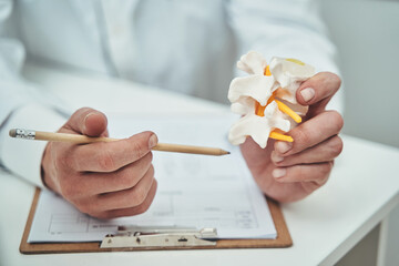 Vertebrologist sitting at the table in his private office