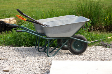 Two shovels, two wheelbarrows, a bucket for landscaping.