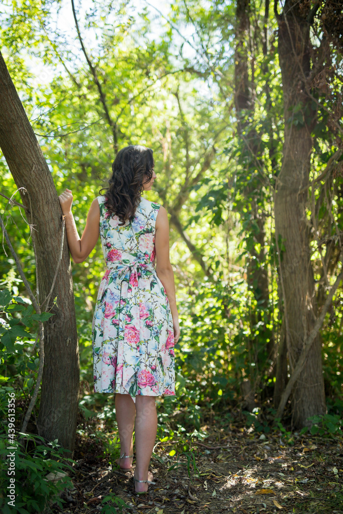 Wall mural unrecognizable woman with a floral dress posing in the forest