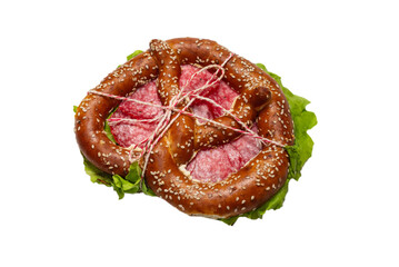 Pretzel with salami and lettuce isolated on a white background.