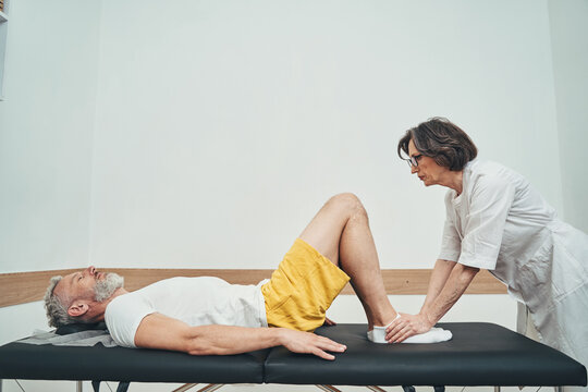 Female osteopath carrying out a manual muscle strength test