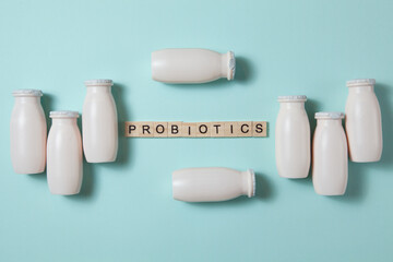 Bottles with probiotics and prebiotics dairy drink on light blue background.