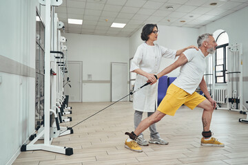 Athlete performing a strength exercise supervised by a physiotherapist