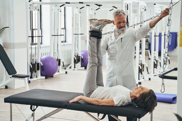Woman performing a strength training exercise assisted by a kinesiologist