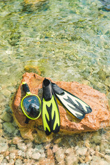 Fototapeta na wymiar snorkeling mask with flippers at rock in sea water