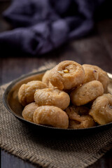 Indian traditional sweet balushahi served on a metal plate on wooden background