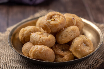 Indian traditional sweet balushahi served on a metal plate on wooden background