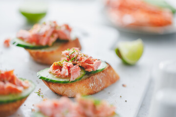 Toasts with smoked salmon and fresh cucumber served with lime shavings.
