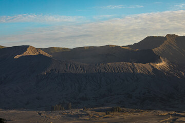 Naklejka premium Bromo active volcano natural landscape at sunset, part of the Tengger massif, seen from Cemoro Lawang village, in East Java province, Indonesia