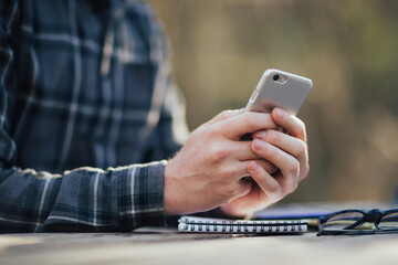 Close-up of male hands are holding and using modern smartphone.